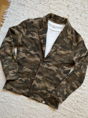 *Unik* Camo Kavaj/Cardigan - Woolrich - En sjukt snygg kavaj/cardigan med i en sällsynt design från det kvalitativa märket Woolrich! Storlek small och extremt bra passform. Hör av dig vid frågor.