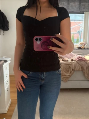 Svart ribbad t-shirt från Anna Field - Säljer en svart ribbad t-shirt från Anna field med snygg sweetheart-ringning och korta ärmar. T-shirten har en tight passform.