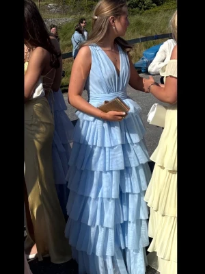 Ljusblå volangklänning med v-ringning - Säljer min ljusblå balklänning i storlek 36 från Bubbleroom. Klänningen är bara använd 1 gång men har inga tecken på användning. Klänningen finns inte längre att köpa på hemsidan. Nypris är 1 799 kr❤️