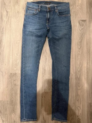 Nudie Jeans Tight Terry Jeans Blå W31/L34 - Skinny Fit - Nudie Tight Terry blå jeans med skinny fit passform som sitter väldigt tight och bekvämt och funkar till allt, storlek W31/L34, midja 39,5 cm, ytterbenslängd 107,5 cm, benöppning 14,5 cm, modellen är 185cm & väger 65kg, i fint skick.
