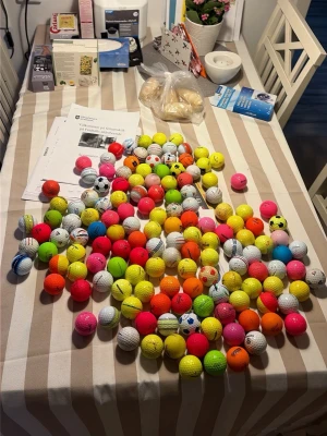 Stort blandat paket golfbollar - Säljer ett stort paket med blandade golfbollar i olika färger som neonrosa, gul, orange, vit och fler. Vissa bollar har mönster eller loggor, och de flesta är av plast eller gummi. Perfekt för dig som vill ha många bollar till träning eller spel.