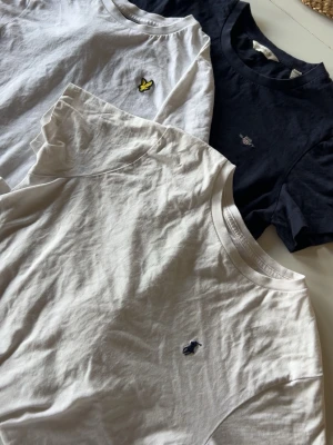 3 t-shirts med broderade loggor - Säljer tre t-shirts i bomull: en vit med gul broderad logga från Lyle & Scott, en marinblå med liten broderad logga från gant och en vit med blå broderad logga från Ralph Lauren. Alla har rund hals och korta ärmar. Alla är även äkta, från kidsbrandstore. Man kan gärna komma med förslag på pris. Kom privat för att diskutera, de kostar inte 1kr. 