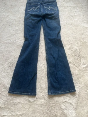 Blå bootcut jeans med broderade fickor - Säljer ett par blå bootcut jeans från Nelly som är typ helt oanvända. 