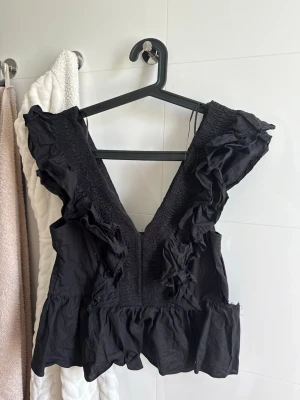 Svart volang topp med v-ringning - Säljer min svarta topp från H&M då den tyvärr gått sönder och vet inte hur jag ska laga den. Om någon vill ha den och försöka laga den så kan vi diskutera pris! Tror de ska funka med vanlig sy tråd men är inte säker.