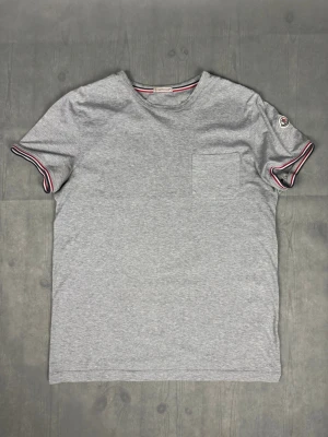 Moncler t-shirt - Moncler t-shirt Märke: Moncler Storlek: S/M Passform: Färg: Grå Skick: Bra Beskrivning: utan defekter, lite missfärgad i armhålorna. Modellen på bilden: 183 cm / 75 kg