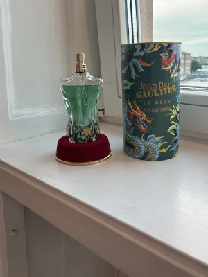 Jean Paul Gaultier Le Beau Paradise Garden 125ml 🌴 - Säljer min Jean Paul Gaultier Le Beau Paradise Garden 125 ml.  100% äkta parfym. Originalförpackning, burk och allt övrigt som följde med vid köp ingår. Mycket parfym kvar i flaskan, se bilder för exakt nivå.  Säljer den till ett bra pris eftersom jag behöver få in lite pengar snabbt.  ✅ 125 ml ✅ 100% äkta ✅ Originalburk/förpackning ingår ✅ Allt original  Pris: [450 kr]  Skicka gärna meddelande vid frågor eller intresse.