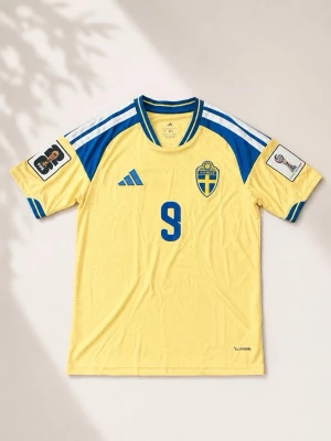 Sverige fotbollströja Gyökeres 17 Adidas - Gul Sverige fotbollströja från Adidas med blå detaljer, nummer 17 och namnet Gyökeres på ryggen. Tröjan har blå Adidas-logga, landslagsemblem och Climacool-material för bra ventilation. Perfekt för fotbollsfans som vill stötta landslaget.