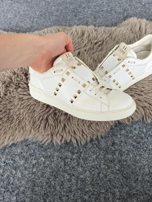 Valentino Garavani Open Rockstud - Supersnygga Valentino Rockstud Untitled sneakers i storlek 43. Jag har kvar orginalbox samt dustbags, vilket följer med vid köp (skriv om du vill se bilder). Nya kostade de 8000 kr, vilket gör mitt pris relativt billigt. Observera att de har en liten slitning vid ena framtån, men i övrigt är de i mycket bra skick. Hör av dig vid minsta fundering! 😃