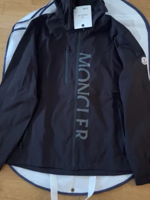 Svart vindjacka från Moncler - Perfekt windbreaker för blåsiga, regniga dagar. Men även i värmen, den är tunn och skön och är bra för våren och hösten men även sommaren. Finns i storlek L och M. Pris kan alltid diskuteras så kom med rimliga bud!