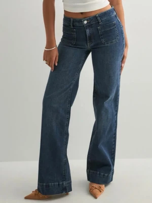 Helt nya wide leg jeans med lapp kvar - Köpta för 699! Snygga mörkblå jeans med wide leg-modell och hög midja. Jeansen har framfickor med synliga sömmar och klassisk knappgylf. Perfekta för en trendig och avslappnad stil. Tillverkade i denim med lite stretch för extra komfort.