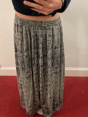 Mönstrad långkjol från Zara - Säljer en långkjol från Zara med grönt mönster. Kjolen har resår i midjan och ett flowy fall som ger en avslappnad vibe. Har bara använt 2 gånger. Jättefin grön färg! 🤗