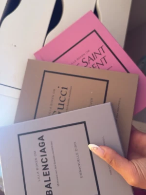 Tre stilrena modeböcker - Säljer tre snygga böcker om Balenciaga, Gucci och Yves Saint Laurent. Böckerna har mjuka omslag i grått, beige och rosa med minimalistisk design och svart text. Perfekta för dig som älskar mode och vill ha inspiration från ikoniska modehus.
