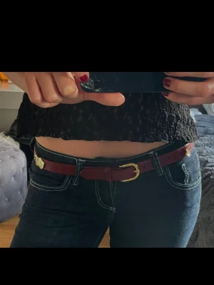 Upcycled unikt skärp - Ett Upcycled läder-skärp i burgundy färg med guld detaljer.🌹💫 Hela skärpet är 100 cm långt.