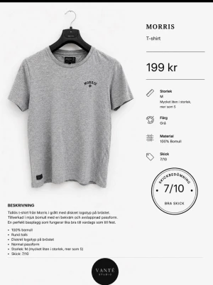 Grå t-shirt från Morris - Klassisk grå t-shirt från Morris med rund hals och diskret logotyp på bröstet. Tillverkad i mjuk bomull och har en normal passform som känns både bekväm och stilren. Perfekt till jeans eller shorts för en enkel look.
