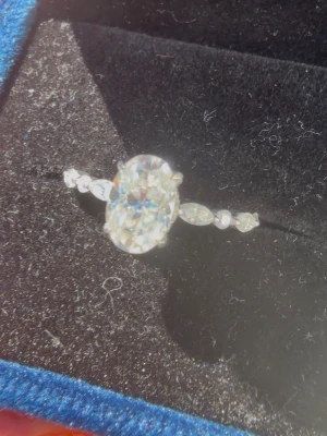 Moissanite Ring 1.5 Carat – 18K Vitguldspläterad – Certifikat & Box - Säljer en helt ny ring med 1.5 ct moissanite i klassisk och elegant design. Perfekt som present eller förlovningsring.  • Moissanite (1.5 ct centersten)   • Oval briljantslipning   • Sidostenar: 0.30 ct totalt   • Färg: E–F   • Klarhet: VVS   • Material: 925 sterling silver med 18K vitguldsplätering   • Storlek: 17.5 mm innerdiameter (EU 55)   • Certifikat medföljer   • Premium box medföljer   • Helt ny  Pris: 5 500 kr  Jag är inte låst vid priset och lyssnar gärna på seriösa bud. 