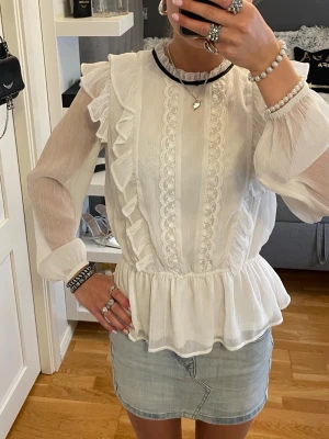 Vit volangblus med spetsdetaljer - Jättefin vit blus med volanger på. Perfekt nu till sommarens alla tillfällen! Passar XS