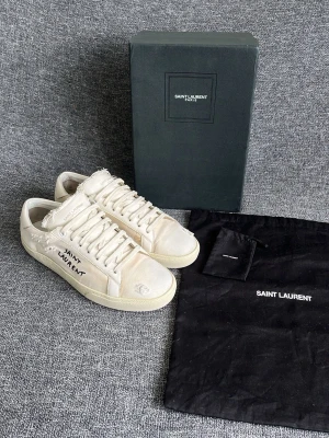 Saint Laurent skor - Hej, vit/krämvita Saint Laurent skor i nyskick. Box, dustbag och snörpåse medföljer i köpet! Skorna är nyimpregnerade och färdiga för nästa användare! Inga defekter förekommer,och designen ska vara sliten. Som nya! Nyvärde på 8000kr+. Tillverkade i Italien! Hör gärna av dig! Mvh DS