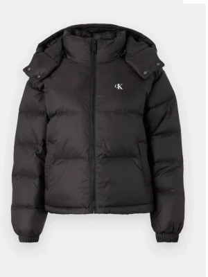 Svart pufferjacka från Calvin Klein - Snygg svart pufferjacka från Calvin Klein med avtagbar huva och dragkedja framtill. Jackan har två sidofickor med dragkedja och elastiska muddar vid ärmsluten. Diskret CK-logga på bröstet. Perfekt för kalla vinterdagar.