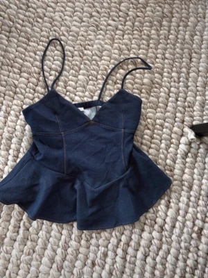 Mörkblå peplum linnetopp zara - Snygg mörkblå linnetopp med smala axelband och peplumvolang nedtill. Toppen har markerade sömmar och en v-ringad skärning framtill. Perfekt för dig som vill ha en trendig och feminin look. Från Zara aldrig använd passar tyvärr inte mig💕