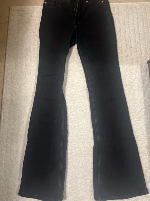 Svarta/urtvättad hödmidjaj bootcut jeans - Säljer ett par högmidjade svarta bootcut jeans 