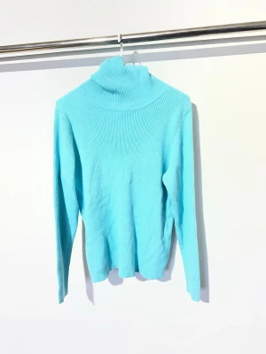 Turkos ribbad polotröja Lauren Ralph Lauren - Snygg turkos stickad polotröja med ribbad struktur och långa ärmar. Perfekt för lager på lager och ger en fräsch färgklick till din outfit. Polokragen är hög och mjuk, vilket gör tröjan både trendig och bekväm.