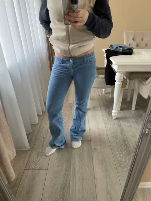 Ljusblå utsvängda jeans  - Säljer ett par ljusblå manchesterbyxor med utsvängda ben och klassisk femficksmodell. Byxorna har normal midja och stängs med knapp och dragkedja. Perfekta för dig som gillar retrostil och mjukt material.