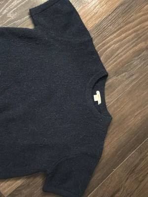 Mörkblå stickad t-shirt från Ginatricot - Kortärmad stickad t-shirt i mörkblått från Ginatricot. Den e knappt använd och i superbra skick. Storlek 146/152