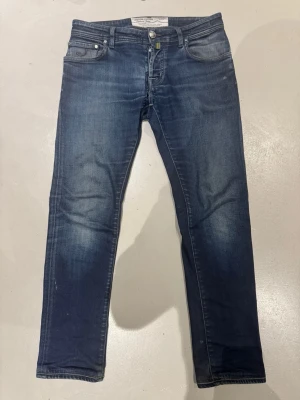 Jacob cöhen jeans - Snygga mörkblå slim fit jeans från jacob cöhen med klassisk femficksmodell och subtila slitningar på låren. Jeansen har normal midja, dragkedjegylf och är tillverkade i stretchig denim för extra komfort. 