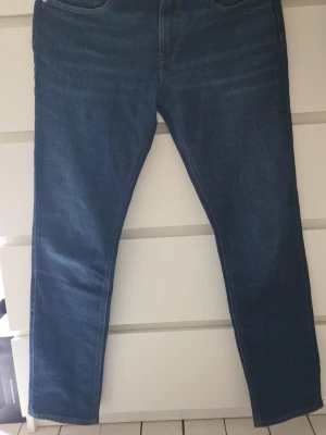 Mörkblå raka jeans - Säljer ett par klassiska mörkblå jeans med rak passform och fem fickor. Jeansen har normal midja och är tillverkade i ett mjukt denimtyg. Perfekta till en avslappnad stil och funkar året runt.