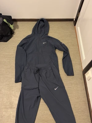 Nike Running svarta träningsbyxor - Säljer ett par svarta träningsbyxor från Nike Running med resår i midjan och benslut. Byxorna har en enkel och stilren design med Nike-logga på benet. Perfekta för löpning eller gym. Tillverkade i lätt och snabbtorkande material.