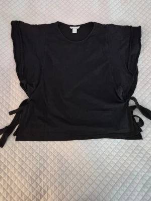 Blus med stora volangärmar  - Blus i bomull från H&M med stora volangärmar🌟 Har knytband i sidorna. Mycket fint skick och knappt använd. Storlek M men jag brukar bära XS. 