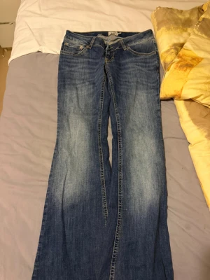 Blå bootcut jeans från 157 - Säljer ett par klassiska blå bootcut jeans från 157 med snygg slitning framtill. Jeansen har fem fickor, normalhög midja och är tillverkade i denim med lite stretch. Perfekta för dig som gillar en avslappnad och tidlös stil.                                         ‼️Har bara testat dom aldrig använt‼️ 
