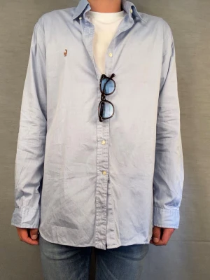 Ralph lauren skjorta L - Säljer denna stört feta ralph lauren skjorta. En av de fräschaste man kan ha i sommar! Size L. Modellen är 180, rekomenderad längd: 190-195cm. Skick: 8/10. Midja 55cm längd 79cm. Skriv vid intresse 😄