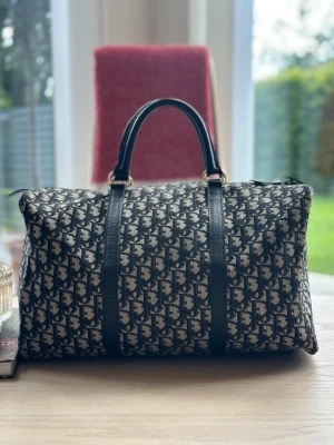 Christian Dior Trotter Boston väska  - Säljer nu denna vintage Christian dior trotter Boston väska. Väskan är köpt i Paris på slutet av 80-talet av min farmor och hittades nu i ovanligt bra skick i hennes källare.     Hör av er om ni har frågor😊