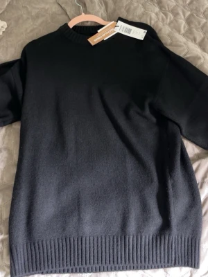 Jack and Jones stickad tröja  - En enkel och stilren svart stickad tröja med rund hals och ribbade muddar. Perfekt basplagg till garderoben och funkar till det mesta. Tröjan har en klassisk passform och är mjuk och skön.