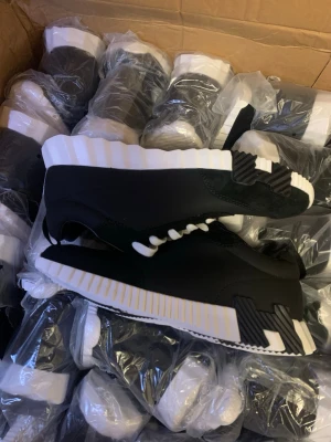 Svarta sneakers med vit sula - Snygga svarta sneakers med chunky, räfflad vit sula och svarta detaljer undertill. Skorna har en låg profil och vita snören som kontrast. Materialet ser ut att vara en mix av syntet och mockaimitation. Perfekta för dig som gillar streetwear och vill sticka ut. Finns alla storlekar 