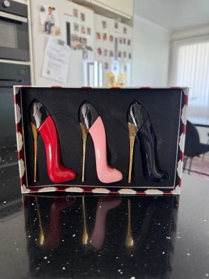 Good Girl parfymset carolina herrera - Unikt parfymset från Carolina Herrera med tre miniflaskor i form av högklackade skor. Färgerna är röd, rosa och mörkblå med guldfärgade klackar. Flakongerna är snyggt förpackade i en ask med hjärtmönster och guldiga detaljer.