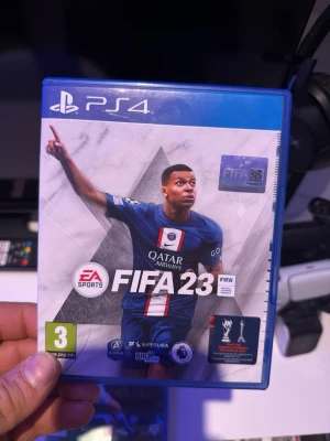 FIFA 23  - FIFA 23 till PlayStation 4 med blå plastfodral och originalskiva. Omslaget har en fotbollsspelare i blå matchtröja och spelet är märkt med PEGI 3. Perfekt för dig som gillar fotbollsspel och vill bygga ditt eget drömlag.