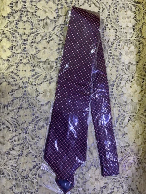 Helt ny  slips  - Snygg mörklila slips med diskret rutmönster i rosa och vitt. Slipsen har en klassisk form och är tillverkad i ett glansigt material som ger en elegant känsla. Perfekt accessoar för att lyfta din outfit med lite extra färg.  99kr/st helt ny 