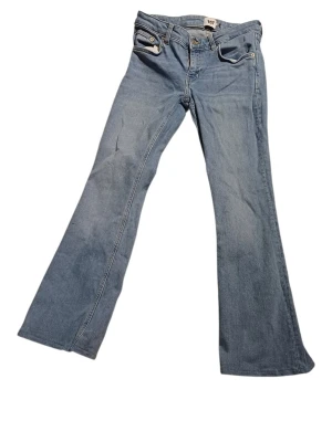 Bootcut jeans från 157 i ljusblå denim - Säljer ett par ljusblå bootcut jeans från 157 med klassisk femficksmodell och snygga kontrastsömmar. Jeansen har normal midja och är tillverkade i mjuk denim med dragkedjegylf och knapp. Perfekta för en avslappnad och trendig look.
