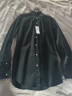 Svart skjorta från Ralph Lauren - Säljer min Ralph Lauren skjorta nu, då jag inte vill ha den längre och storleken är inte perfekt! Helt ny bara prov testad 2 ggr. 