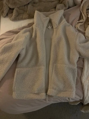 Teddy jacka hm - Säljer en teddy jacka från hm i storlek s. I kräm beige färg. Har ett hål vid en jackfickan (se sista bilden) men går att sy ihop🤗
