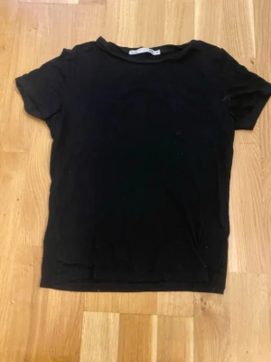 Svart basic t-shirt - En enkel svart t-shirt med rund hals och korta ärmar. Inget tryck eller någonting.