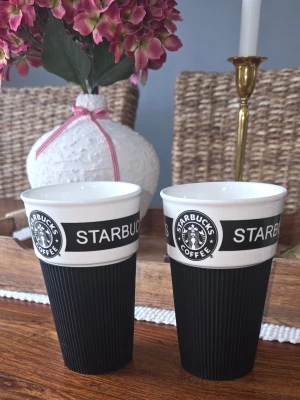 Starbucks kaffemuggar svart/vit 2-pack - Två snygga kaffemuggar från Starbucks i svart och vitt. Tillverkade i keramik med greppvänlig design, perfekta för kaffe eller te hemma.