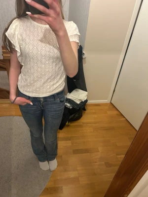 Vit blus med volang - Superfin och elegant blus med fina mönster och volanger i ärmarna. 