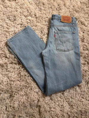 Ljusblå Levi's 551Z straight jeans - Säljer ett par ljusblå Levi's 551Z straight jeans i klassisk denim. Jeansen har fem fickor, Levi's ikoniska röda etikett och patch bak i midjan. Perfekt passform med rak siluett och tidlös look. Materialet är 100% bomull för en äkta jeanskänsla.