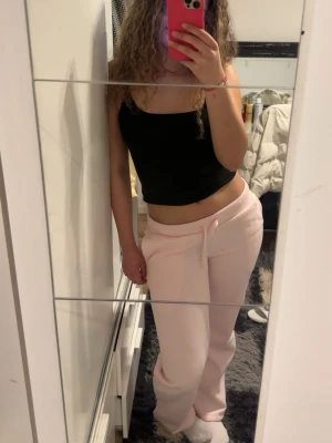 Ljusrosa mjukisbyxor med dragsko - Säljer ett par ljusrosa mjukisbyxor med relaxed fit och dragsko i midjan. Byxorna har raka ben och är perfekta för en chill och avslappnad stil. Tillverkade i mjukt material som känns skönt mot huden. Passar perfekt till hoodies eller croptops.