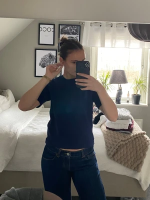 Mörkblå t-shirt från Gina Tricot - En stilren mörkblå t-shirt från Gina Tricot. T-shirten har rund halsringning och korta ärmar. 