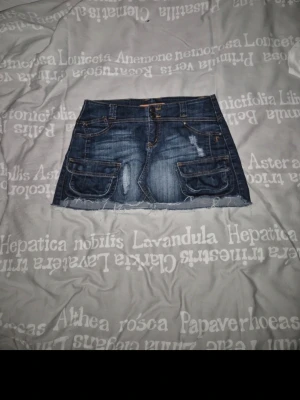 Jeanskjol! - Säljer en supercool jeanskjol! Köpt här på Vinted men aldrig använd, endast testad. Litr småsliten kanske men annars fint skick! Säljer då den inte riktigt sitter bra, faller i min smak och då mörkt denim inte är min grej. Strl 36, midjemått cirka 36-38 cm. Skriv för frågor! Katt finns I hemmet! 