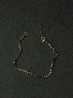Guld Cubansk Armband 18+5cm 3.5mm i Rostfritt Stål - Elegant cubanskt armband i guldton med justerbar längd (18+5cm). Tillverkat i rostfritt stål som är slitstarkt, rostfritt och behåller sin färg över tid. Tunn 3.5mm kedja som ger en diskret men stilren look, perfekt för vardagsbruk eller att kombinera med andra smycken.